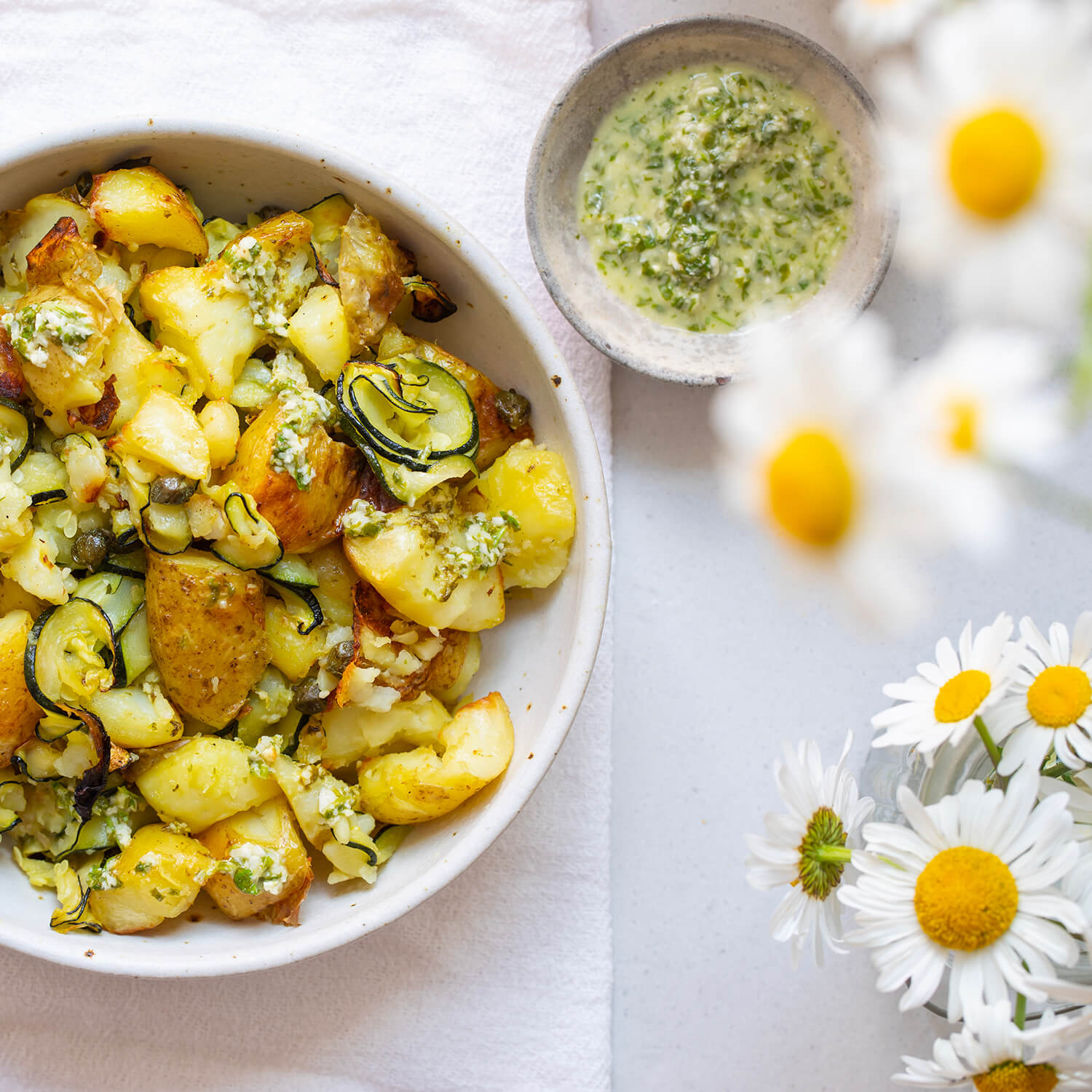Ein mediterraner Kartoffelsalat mit goldbraun gebackenen Kartoffeln, Zucchinistreifen und einem würzigen Kräuterdressing